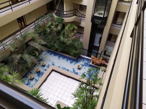 an overhead view of a building with a swimming pool and palm trees at Studio do Bosque in Curitiba