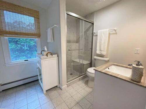 ein Badezimmer mit einer Dusche, einer Badewanne und einem WC in der Unterkunft Wedgewood Cottage in Barnstable