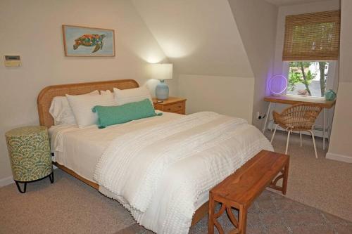 ein Schlafzimmer mit einem Bett mit einem grünen Kissen darauf in der Unterkunft Wedgewood Cottage in Barnstable