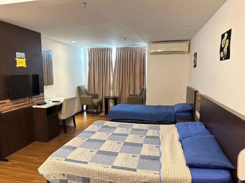 a hotel room with a bed and a desk and a television at Nazrins Studio Apartment KBCP in Kota Bharu
