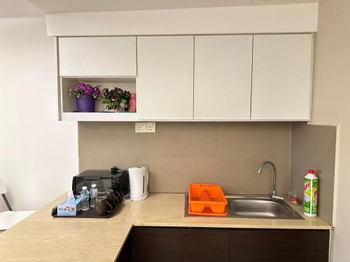 a kitchen with a sink and a counter top at Nazrins Studio Apartment KBCP in Kota Bharu