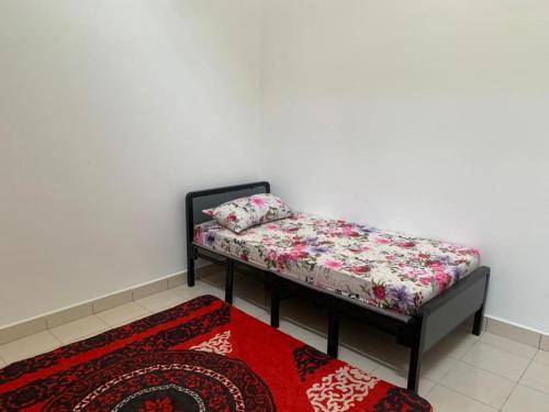 een bank in een kamer met een rood tapijt bij HOMESTAY HONEY PARIT BUNTAR in Parit Buntar