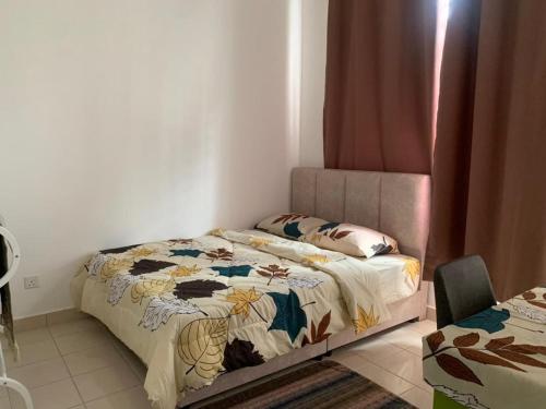 ein Schlafzimmer mit einem Bett mit einer Decke darauf in der Unterkunft HOMESTAY HONEY PARIT BUNTAR in Parit Buntar