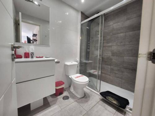 a white bathroom with a shower and a toilet at Happy House Puerta del Sol in Caleta De Fuste