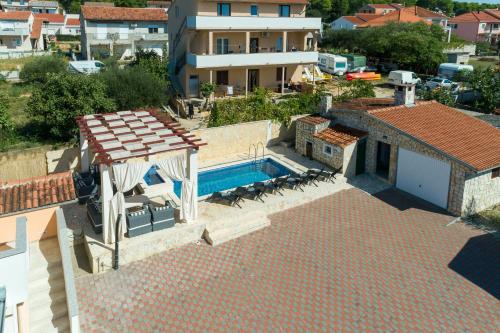 eine Luftansicht eines Hauses mit Pool in der Unterkunft Coastal Paradise Villa with Pool - Happy Rentals in Sveti Filip i Jakov