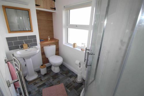 uma casa de banho com um WC, um lavatório e uma janela em The Wabi Sabi House 