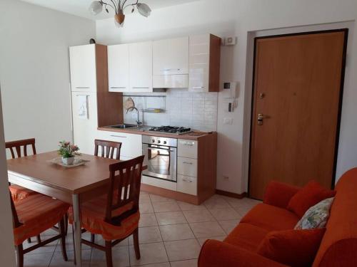 eine Küche und ein Esszimmer mit einem Tisch und einem Sofa in der Unterkunft Appartamento Sirena in Tortoreto Lido
