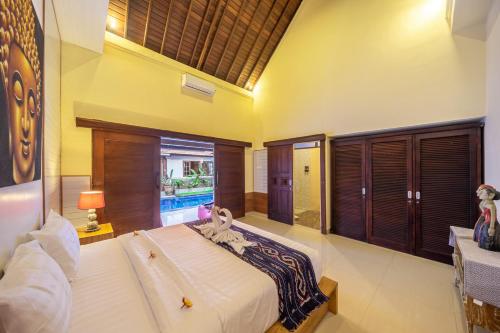 a bedroom with a large bed and a pool at De Gani in Seminyak