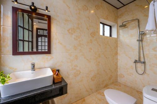a bathroom with a sink and a toilet at Golden Sun Hotel Hoi An in Hoi An