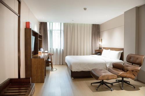 広州市にある客村喆啡酒店（广州国际会议展览中心店）のベッドとデスクが備わるホテルルームです。