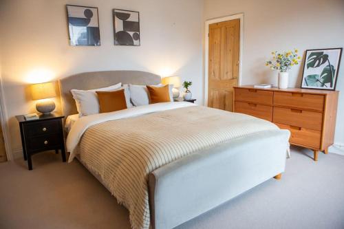 a bedroom with a large bed and a wooden dresser at Cosy Harrogate Haven in Harrogate