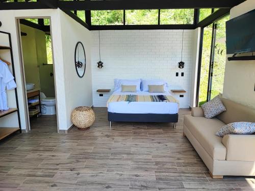 um quarto com uma cama e um sofá em Cabaña Bambú em Ciudad Bolívar