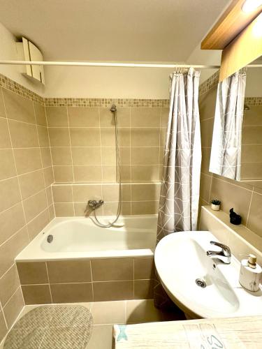 a bathroom with a sink and a bath tub at Central apartment with balcony in Budapest