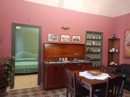 a kitchen with a table and a sink and a bedroom at Casa Castelli Holiday Apartment in Bagheria