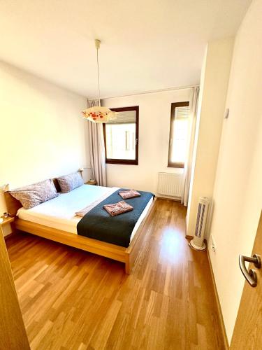 a bedroom with a bed and a wooden floor at Central apartment with balcony in Budapest