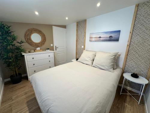 1 dormitorio con cama blanca y espejo en Maison Première ligne Tocade1, en Andernos-les-Bains