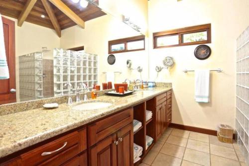 a bathroom with a sink and a large mirror at Casa Buena Vista in Coco