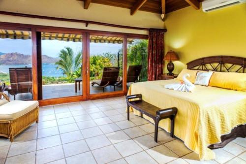 a bedroom with a bed and a view of the ocean at Casa Buena Vista in Coco