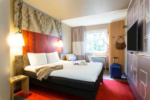 um quarto de hotel com uma cama grande e uma janela em ibis Hotel Hamburg Alster Centrum em Hamburgo