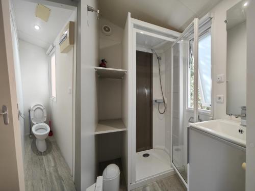 a bathroom with a shower and a toilet and a sink at Mobilandes Sanguinet in Sanguinet