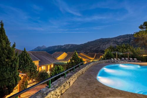 a swimming pool in front of a house at Hotel Alahuar in Benimaurell