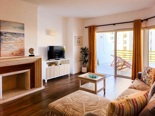 - un salon avec un canapé et une cheminée dans l'établissement FLH Vilamoura Sunny Apartment with Pool, à Vilamoura