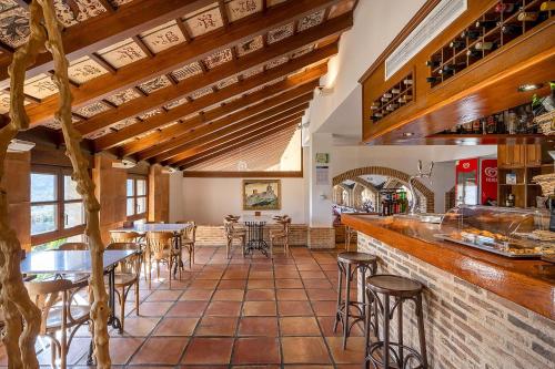 a restaurant with a bar with tables and chairs at Hotel Alahuar in Benimaurell