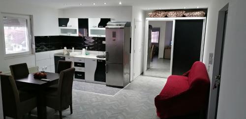 a kitchen and dining room with a red chair and a table at YOUR home in Belgrade