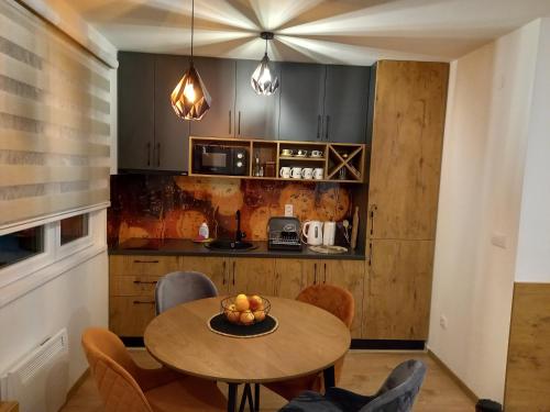 a kitchen with a table with a bowl of fruit on it at Vila Jahor Apartmani Dis 7 i 8 in Jahorina