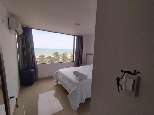 a bedroom with a bed and a large window at RH03 Riohacha apartamento perfecto para trabajar o vacacionar frente a la playa in Ríohacha