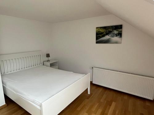 a bedroom with a white bed and a picture on the wall at Irreler Mühle Ferienwohnungen und Ferienhäuser in Irrel