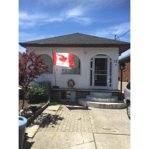 a house with two canadian flags on the front of it at Angelina’s house in Toronto