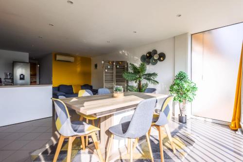 une cuisine et une salle à manger avec une table et des chaises en bois dans l'établissement Cosy apartment 7 minutes walk from the sea!, à Mandelieu-la-Napoule