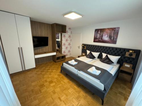 a bedroom with a large bed and a television at Ferienwohnung am Freudenthal in Soltau