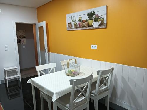 a dining room with a white table and chairs at House da Didy in São João da Pesqueira