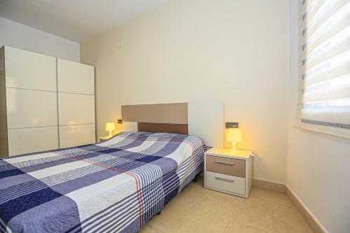 um quarto com uma cama azul e branca e uma janela em Di Mare Litoral Costa Dorada - ONLY FAMILIES em Mont-roig del Camp