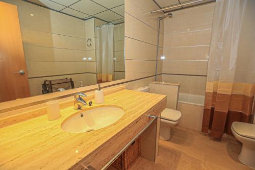 uma casa de banho com um lavatório, um WC e um espelho. em Di Mare Litoral Costa Dorada - ONLY FAMILIES em Mont-roig del Camp