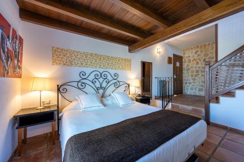 a bedroom with a large bed and a staircase at Hotel Alahuar in Benimaurell