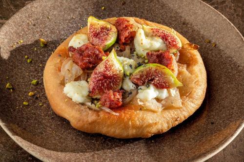a small pizza on a plate on a table at Hotel Alahuar in Benimaurell