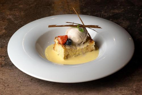 a white plate with a piece of cake with fruit on it at Hotel Alahuar in Benimaurell