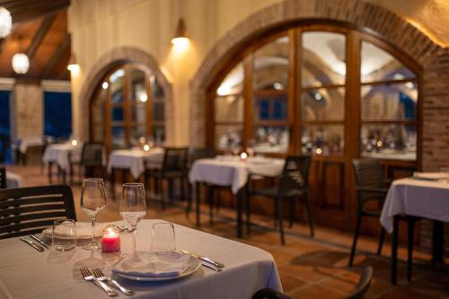 a restaurant with tables with white tablecloths and glasses at Hotel Alahuar in Benimaurell