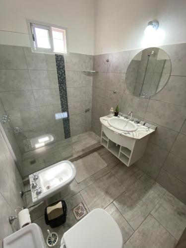 La salle de bains est pourvue d'un lavabo, de toilettes et d'un miroir. dans l'établissement Casa del Valle Merlo, à Merlo