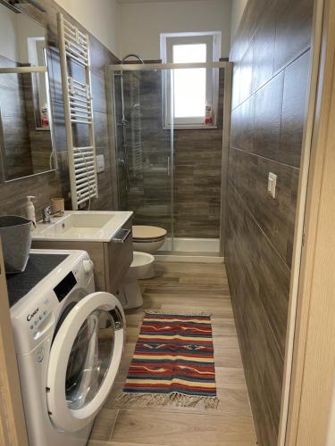 a bathroom with a washing machine and a toilet at Roberta House Rozzano 3 in Rozzano