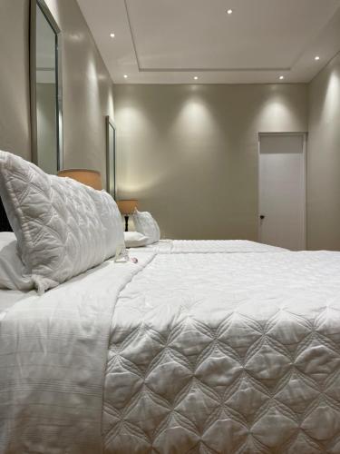 a bedroom with a large white bed with a pillow at Boutique Hotel Belgica in Ponce