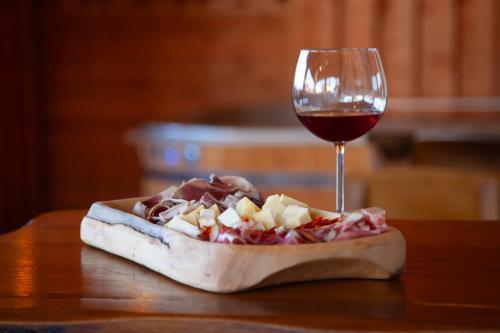 a glass of wine next to a pizza and a glass of food at Sobe App Moj Hir bed and breakfast in Jastrebarsko
