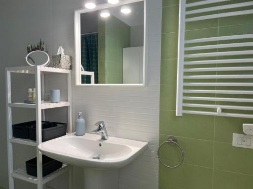 ein Bad mit einem Waschbecken und einem Spiegel in der Unterkunft MyCosmoStudio - Fiera in Pero