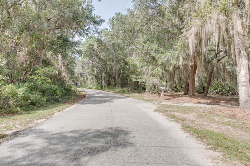 an empty road with trees on either side at Charming Darien Hideaway with Porch, Near Downtown! in Darien