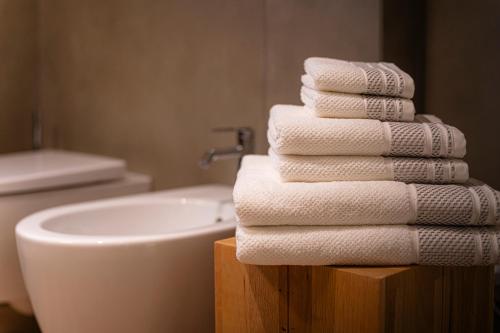a stack of towels on a wooden stand next to a sink at Ca Marièt casa vacanze in Chiavenna