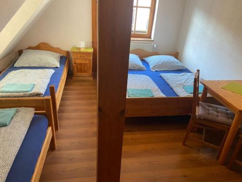 a room with three beds and a table and a desk at Zirndorf Gästehaus in Zirndorf