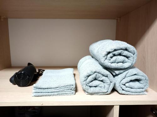 a pile of towels sitting on top of a shelf at AlfaHome Lodz in Łódź